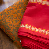 Devi Energised Cotton Saree – Golden Orange with Olive Green Floral Motifs & Vibrant Red Traditional Border
