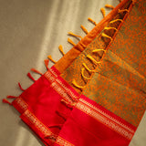 Devi Energised Cotton Saree – Golden Orange with Olive Green Floral Motifs & Vibrant Red Traditional Border